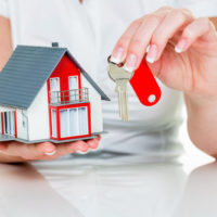 Woman holding a house and keys Woman holding a house and keys