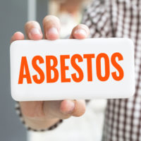 Man holding asbestos sign