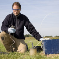 Researcher taking samples from groundwater for environmental research.
