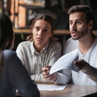 Angry couple arguing with bank manager complain on bad contract