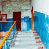 A staircase leading to the last floor of a dilapidated building.