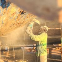 Boat Hull repairs / A man using grinder in preparation for anti foul paint being applied